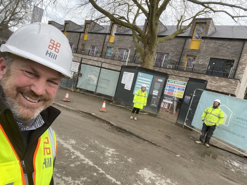 three people stood outside a construction site