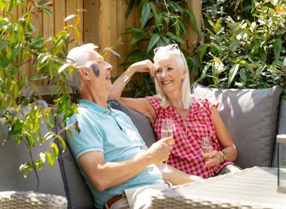 Older couple sat in their garden at their home in Canalside Quarter