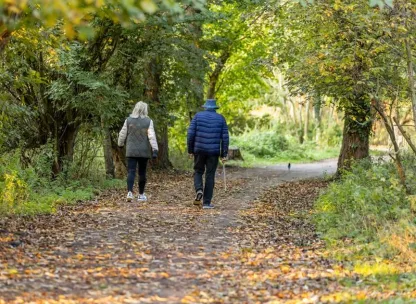 Couple walking their dog in a wooded area