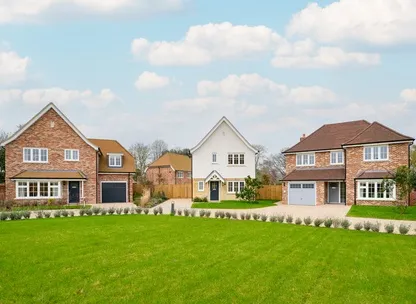 Exterior of modern homes with green lawns at Millside Grange development Hertfordshire