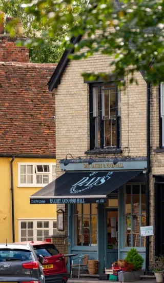View through a tree lined street facing a small local shop