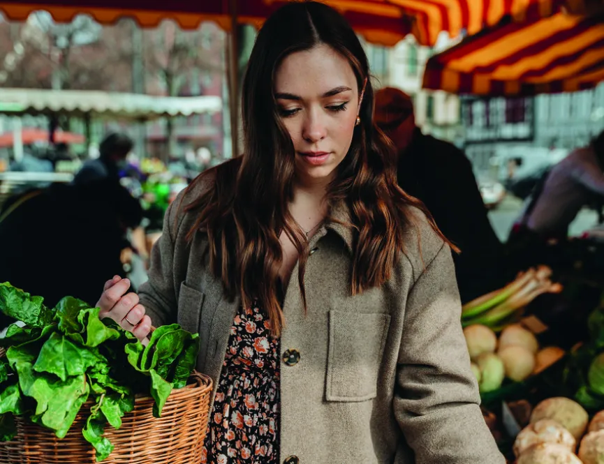 Young woman shopping for vegetables at a local market